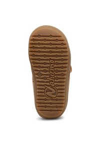Suela de goma color tan con patrón de agarre texturizado y logo. Forma redondeada, con ranuras y crestas para mayor tracción. Diseño ligero.