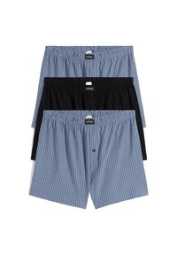 Tre paia di boxer casual da uomo, due blu con righe verticali bianche e uno nero solido, disposti piatti e impilati su uno sfondo bianco.