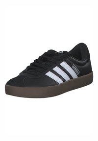 Black athletic shoe with three white stripes, black laces, and a brown rubber sole. Made of leather-like material with a rounded toe.