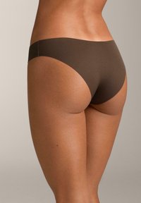 Lenjerie fără cusături maro, cu textură netedă și design cu talie medie, având o croială minimalistă și fără cusături vizibile.