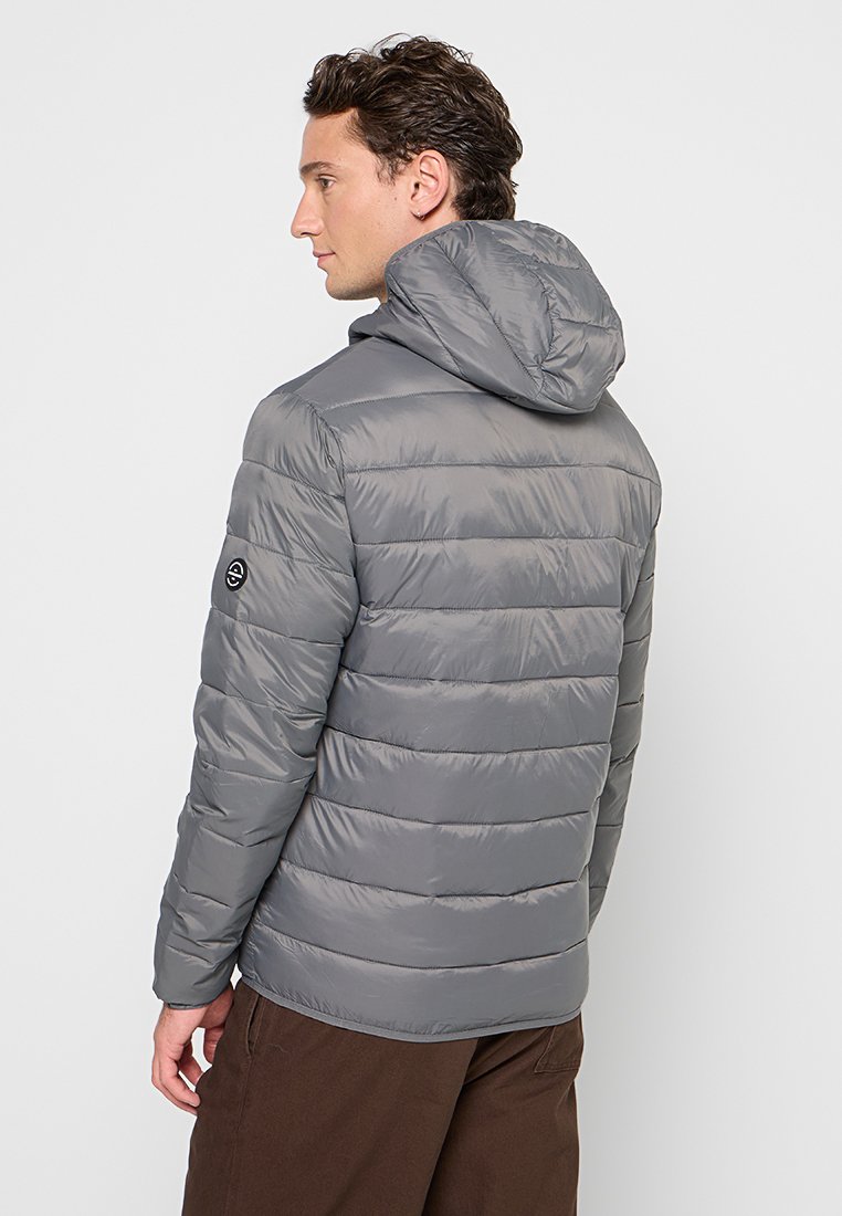 Chaqueta acolchada gris con capucha, que presenta secciones acolchadas horizontales y un logotipo discreto en la manga. Material suave y duradero.