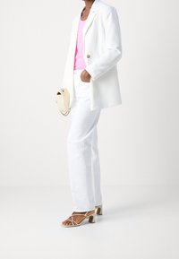 Blazer blanco, top de tirantes rosa, pantalones blancos, bolso beige, tacones con tiras y tacón cuadrado. Diseño minimalista, textura suave, paleta de colores cohesiva.