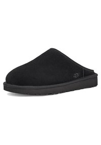 Svart semsket slip-on sko med rund tå, lav hæl og teksturert overflate; har gummisåle og logo på siden.