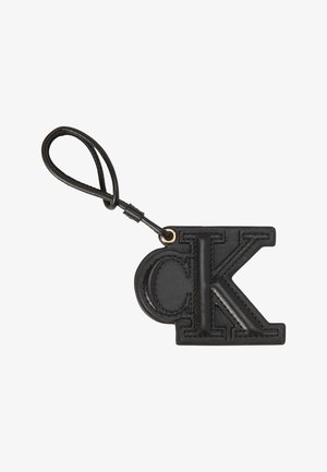 Portachiavi in pelle nera con lettere "cK" ricamate e un anello con cinturino a forma di loop fissato da un anello metallico.
