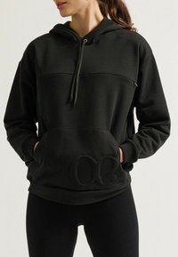 Schwarzer Kapuzenpullover mit Fronttasche, gerippten Bündchen und einem strukturierten Logodetail. Hergestellt aus weichem Stoff mit relaxed Fit.