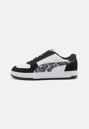 Sneaker bianche e nere con una parte superiore in suede testurizzato e liscia, caratterizzate da un motivo in pelle di serpente sui lati e una suola in gomma.