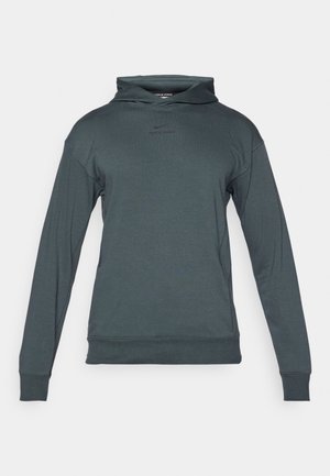 Pilkas Nike Pro džemperis su priekiniais kišeniniais kišene, ilgomis rankovėmis ir dvigubu kapuciu. Pasižymi subtiliu logotipu ant krūtinės.