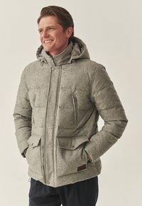 Hall riidest voodriga kapuutsiga jope, millel on ees taskud, tekstuuriga kangas ja nööpkinnitused, esitatud neutraalsel taustal.