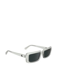 Ochelari de soare cu ramă transparentă și lentile fumurii negre. Formă pătrată. Prezintă logo pe lateral. Design minimalist cu brațe drepte.