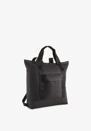 Sac fourre-tout en tissu noir avec deux poignées courtes et des bretelles d'épaule réglables. Comprend une poche avant et un logo sur le côté. Texture lisse.