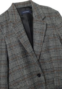 Grijs geruit colbert met zwart, wit en bruin patroon, gestructureerde schouders, enkele knoopsluiting en een zwarte satijnen voering.