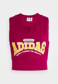 Maročné bezramínkové crop top z bavlny. Vybavený V-výstřihem, odvážným žlutým logem "ADIDAS" a textem "ORIGINALS" v černé a žluté barvě.