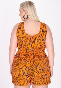 Orange ärmlös jumpsuit med en tigertryck i svart och blått, med en rundad rygg och ett elastiskt midjeband för form.