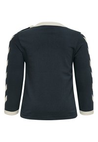 Långärmad skjorta i mörk marinblå bomull, med en krämfärgad ribbad krage och krämfärgad chevronmönster längs ärmarna. Bakvy visas.