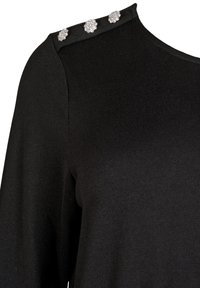 Schwarzes Strickoberteil mit Rundhalsausschnitt, langen Ärmeln und drei dekorativen silbernen Verzierungen an der Schulter.