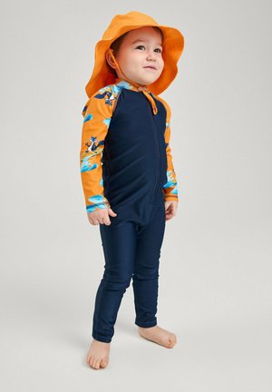 Costume da bagno per bambini composto da una maglietta a maniche lunghe arancione con grafiche acquatiche blu e pantaloni blu scuro, abbinato a un cappello da sole arancione.
