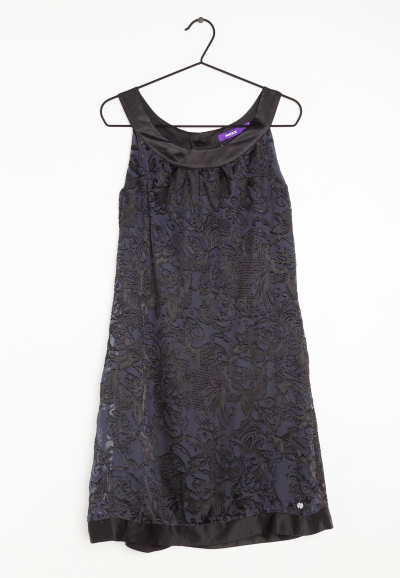 Robe noire sans manches avec superposition en dentelle florale et bordure en satin au niveau de l'encolure et de l'ourlet, suspendue sur un cintre en fil noir sur fond blanc.