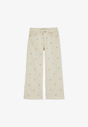Krém színű, bőszárú farmernadrág, bézs virágmintákkal díszítve. Elöl zsebek és gombos záródás található.