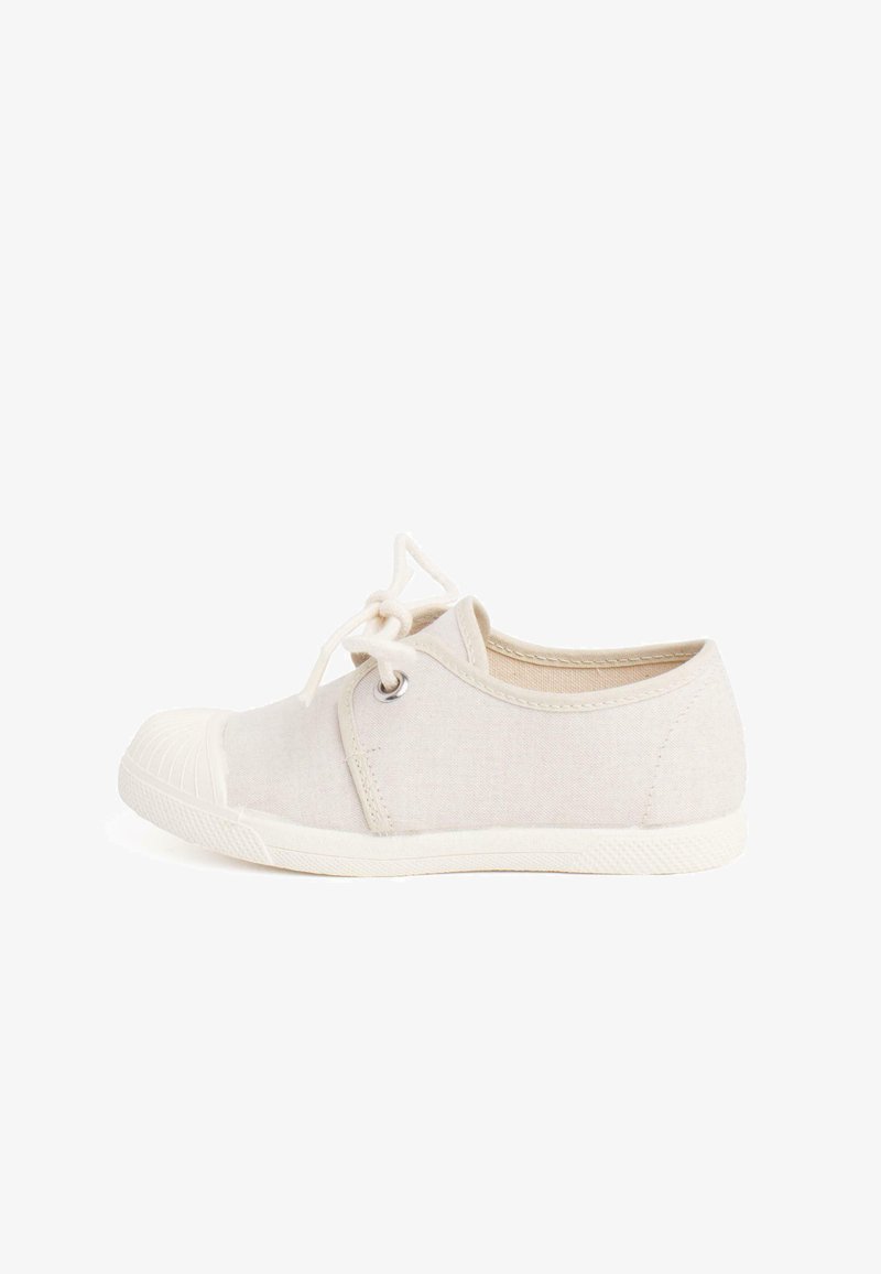 Baskets en toile beige avec un bout rond, semelle en caoutchouc blanc et détails texturés. Elles disposent de lacets en coton et d'œillets en métal pour la fermeture.
