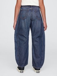 Dark blue denim trousers with a loose fit, featuring five pockets, subtle stitching, and a straight leg design. Worn with black sneakers.