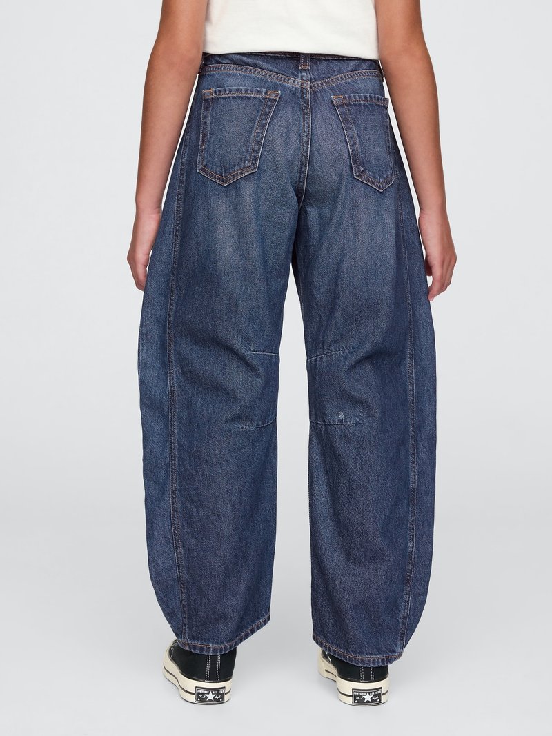 Dunkelblaue Denim-Hosen mit lockerer Passform, die fünf Taschen, dezente Nähte und ein gerades Bein-Design aufweisen. Getragen mit schwarzen Sneakern.