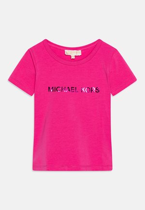 T-shirt rosa acceso a maniche corte con scollo tondo e la scritta "MICHAEL KORS" stampata in lettere nere lucide e rosa sul petto.