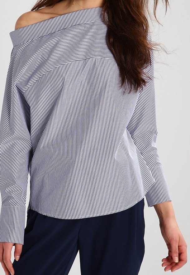 Blusa a strisce off-shoulder in cotone blu navy e bianco, con maniche lunghe e un fit rilassato con colletto ampio.