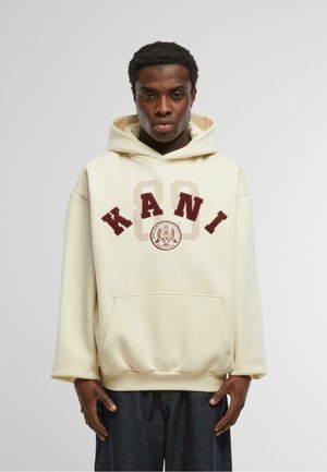Felpa color crema con lettering in bold color bordeaux "KANI" e un logo circolare, dotata di tasca frontale e polsini a coste sul fondo.