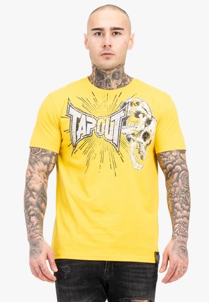 Gul bomuld t-shirt med et grafisk design med teksten "TAPOUT" og et kraniedesign, suppleret med et burstmønster i sort og hvid.