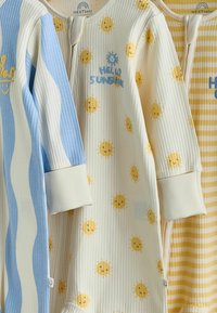 Drei Babystrampler mit langen Ärmeln und gerippter Struktur, versehen mit blau-weißen Streifen, lächelnden Sonnenmotiven mit dem Text "Hello Sunshine" sowie gelben Streifen.