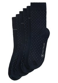 Mörkblå strumpor med prickigt mönster och ribbade fållar, tillverkade av mjukt material. Fem par visas, med en logotyp på sidan.