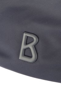 Szary materiałowy worek z wypukłym, szarym plastikowym logo w kształcie litery "B" na teksturowanej powierzchni, podkreślający solidną konstrukcję i materiał.