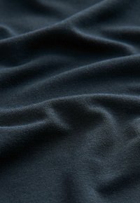 Tume sinine kangas on sileda tekstuuriga, millel on nähtavad kortsud ja voldid, mis viitavad kergele ja venivale materjalile.