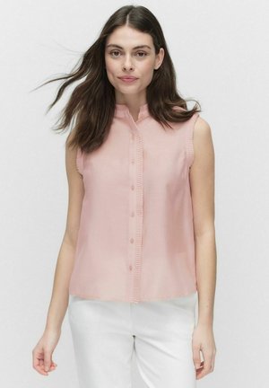 Mouwloze, lichtroze blouse met een hoge kraag, knoopsluiting aan de voorkant en ruches, gemaakt van een gladde, lichte stof.