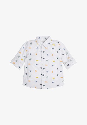 Chemise blanche à manches longues pour tout-petit avec des imprimés colorés d'animaux et de véhicules et des poignets boutonnés.