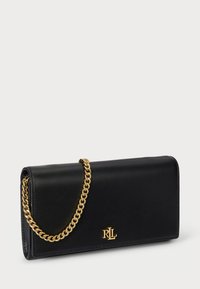 Melnas ādas maku ar zelta ķēdes siksniņu, kurā ir iegravēts logo. Gluda tekstūra, taisnstūra forma un elegants dizains.