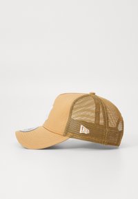 Gul baseballcaps med mesh bakside, med en buet skygge og en hvit logo. Designet for pusteevne og komfort.