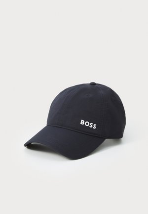 Tumesinine müts, mis on valmistatud kangast, käärmise äärega ja esiküljel valge "BOSS" logo, mille peal on nööpidekood.