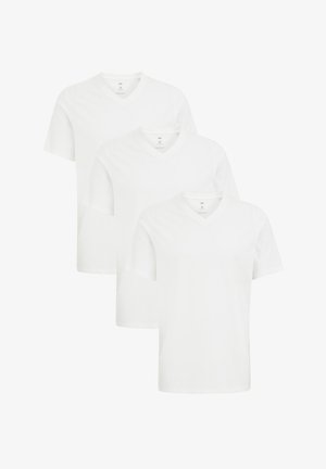 Tre t-shirt bianche di cotone a V sovrapposte, con maniche corte e una superficie liscia. Ogni maglietta ha un'etichetta visibile sul collo.
