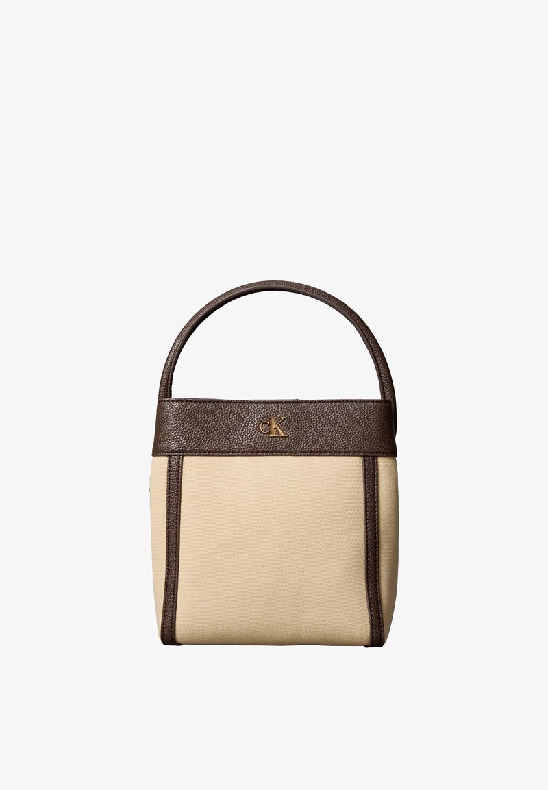 Sac à main rectangulaire beige avec garniture et poignée en cuir marron foncé, avec un petit logo doré "cK" près du centre supérieur.