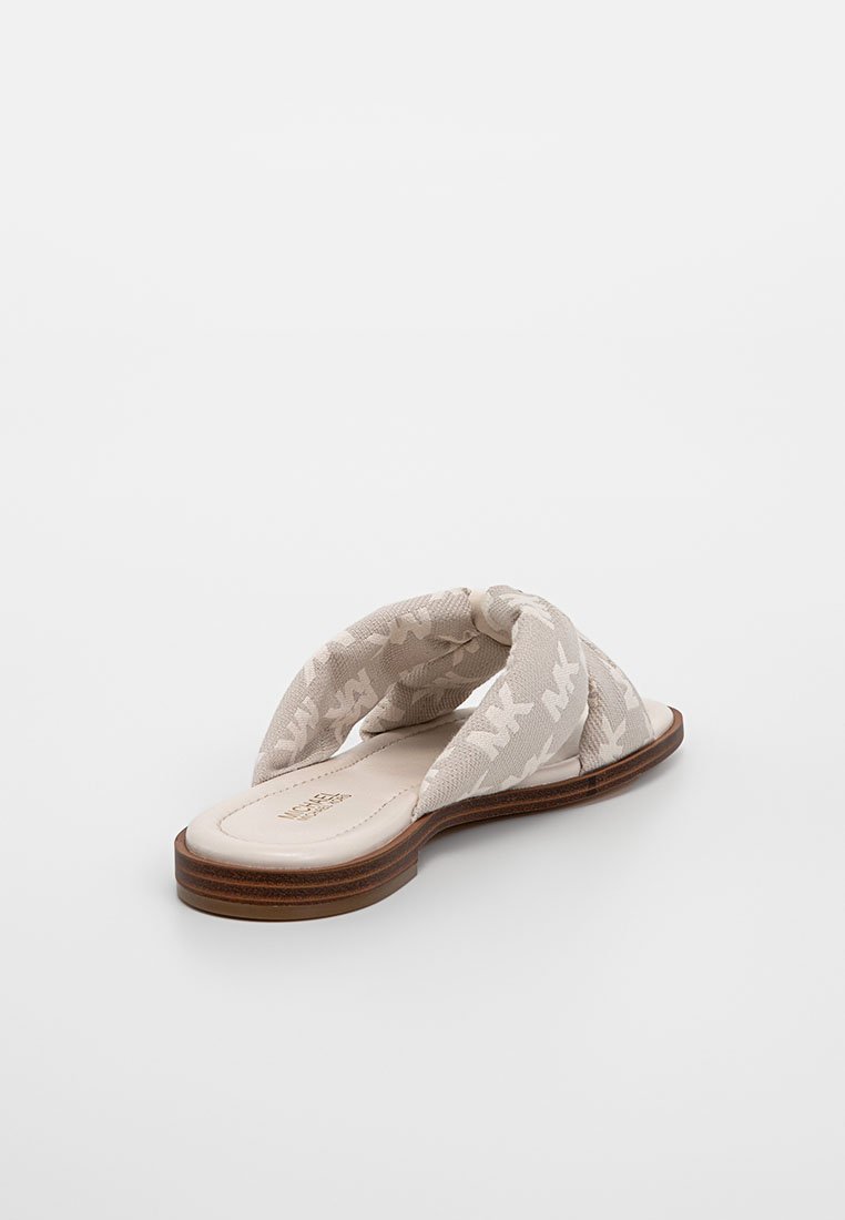 Sandales en tissu beige avec un design supérieur torsadé, dotées d'une semelle en caoutchouc et d'une texture à motifs subtils sur les lanières.