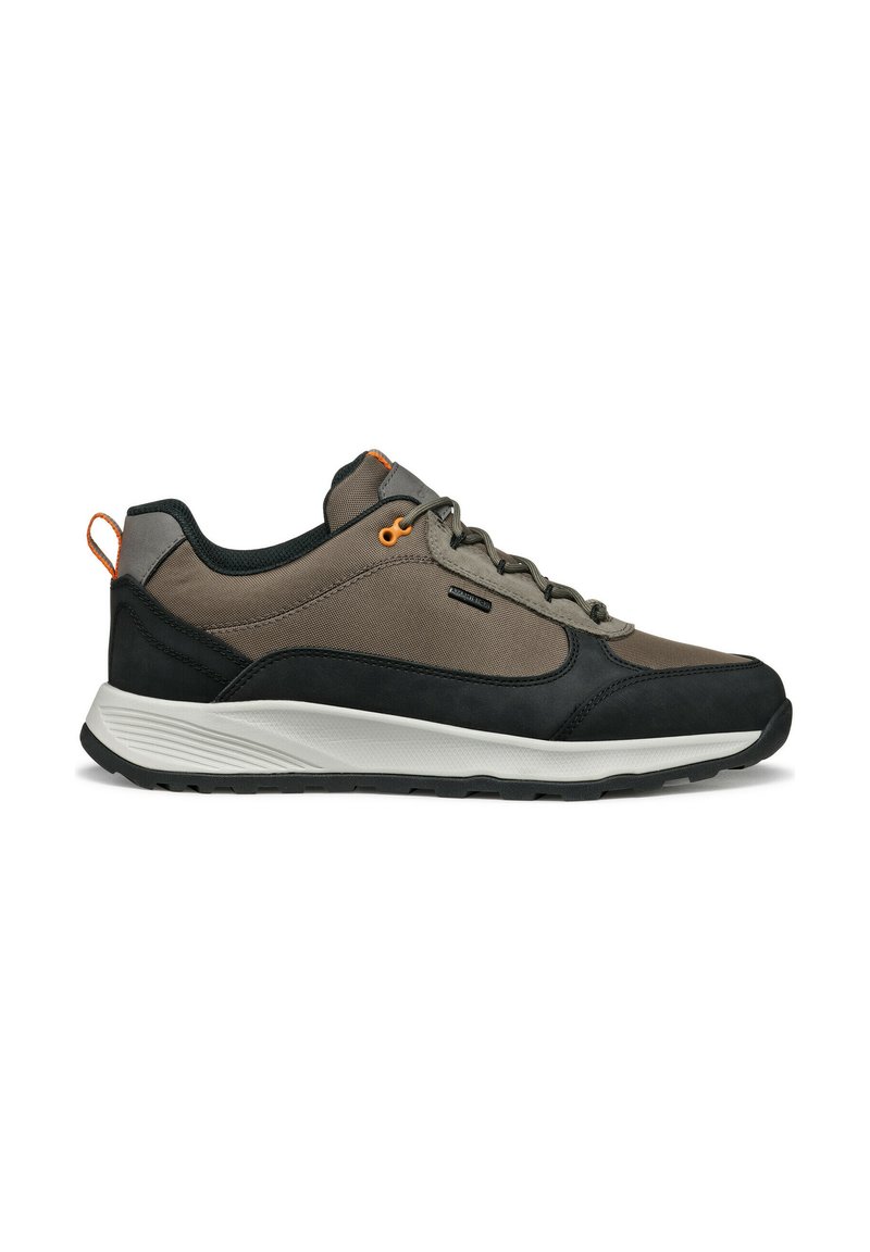 Zapatillas deportivas para hombre con parte superior en gris oscuro y beige, detalles en negro, materiales texturizados, cordones redondos y suela blanca curvada.