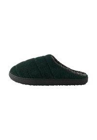 Pantofole verdi in corduroy con texture trapuntata, foderate in morbido grigio e con suola in gomma nera. Design senza lacci con assenza di hardware visibile.