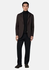 Brūns bleizeris ar kapuci, divām priekšējām kabatām, kopā ar melnu tīkliņu un melnām biksēm. Gluda auduma ar pielāgotu piegriezumu.