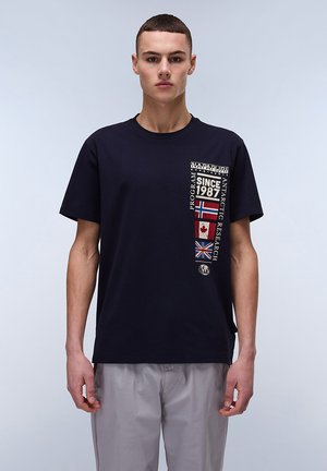 Navy blue cotton t-shirt featuring a graphic design at the chest with country flags and text "SINCE 1987," short sleeves, round neckline.