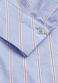 Lichtblauw overhemd manchet met rood en witte verticale strepen en een enkele zilveren knoop met vier gaten bevestigd aan het manchet.