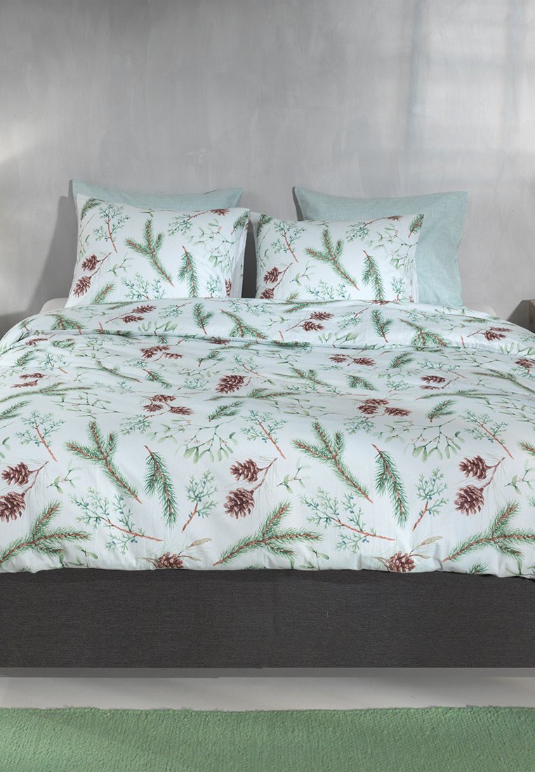 Beddengoed set met een witte achtergrond, groene den takken en bruine dennenappels; zachte textuur; inclusie van bijpassende shams en een effen grijze basis.