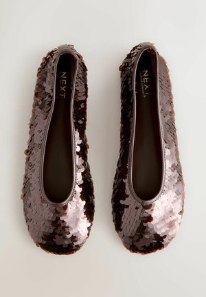 Sötétbarna, flitterekkel díszített balerina cipők, lekerekített orral. A felsőrész apró, fényes flitterekkel van borítva, ami texturált, fényvisszaverő felületet biztosít.