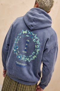 Felpa grigia con un design a forma di farfalla circolare sul retro. Presenta accenti blu-verdi e testo in inglese e in un'altra lingua. Tessuto morbido.