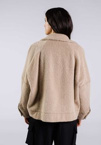 Beige, texturerad oversized jacka med krage och sänkta axlar, som har en lös passform och sidslitsar vid fållen.